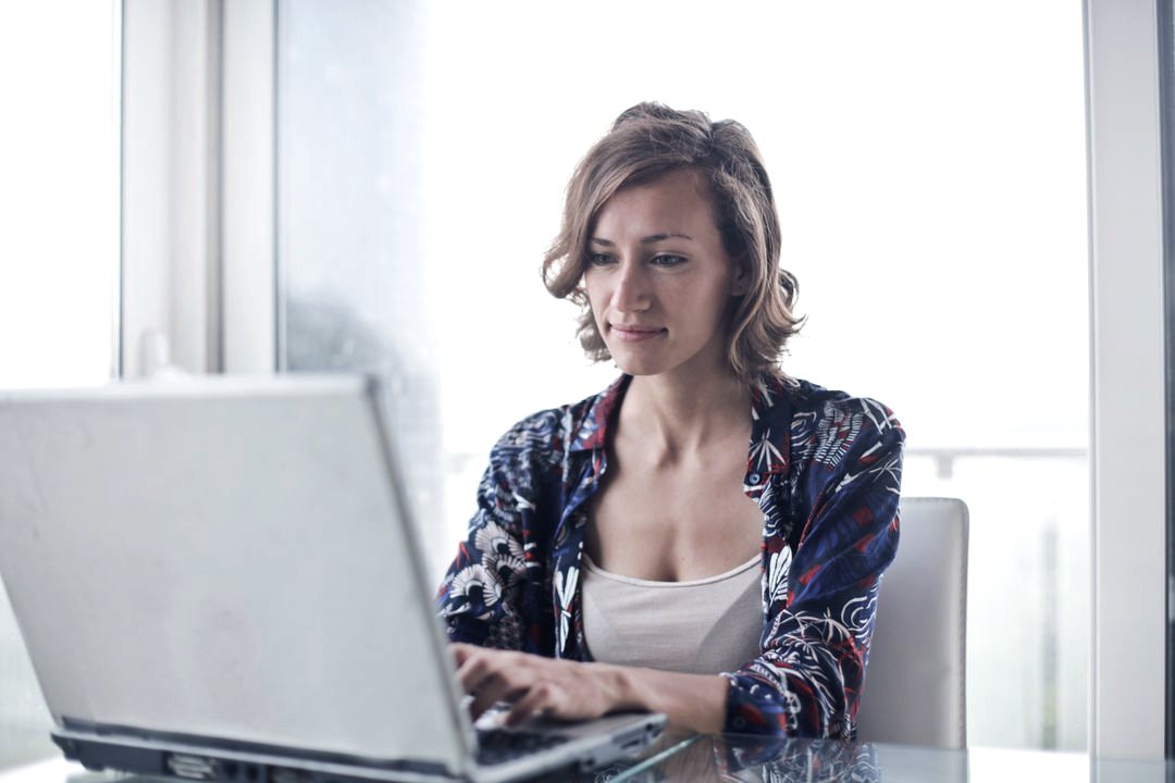 home-office-3tec-blue Woman working on a laptop in a bright home office