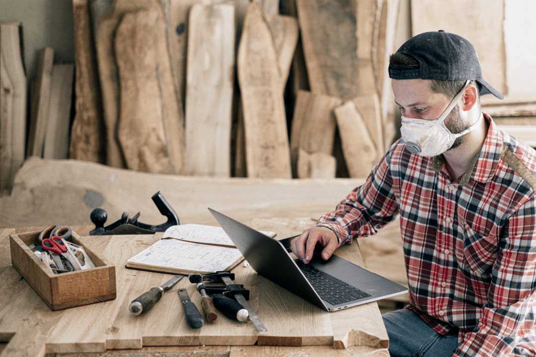 Craftsman using a laptop in a manufacturing workshop